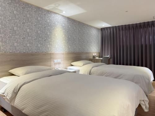 two beds in a hotel room with twoermottermott at 雋格大飯店 Elence Hotel in Taichung