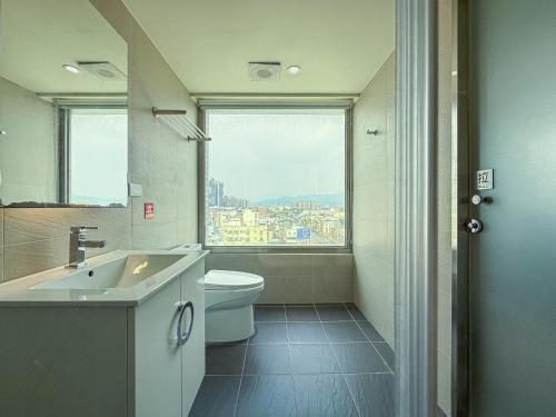 a bathroom with a sink and a toilet and a window at 雋格大飯店 Elence Hotel in Taichung