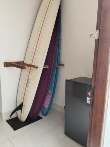 three surfboards are lined up against a wall at Spear Villa in Bumbang