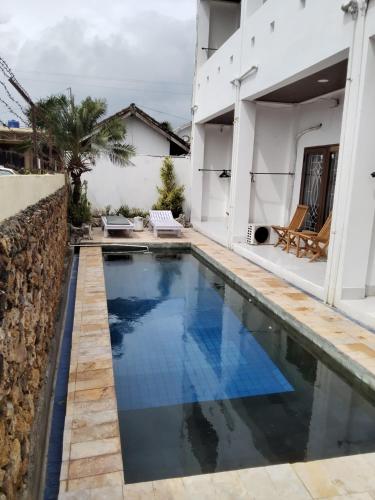 a swimming pool in front of a house at Spear Villa in Bumbang