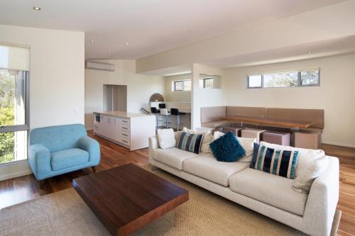 a living room with a couch and a blue chair at Dunsborough Seascape in Quindalup