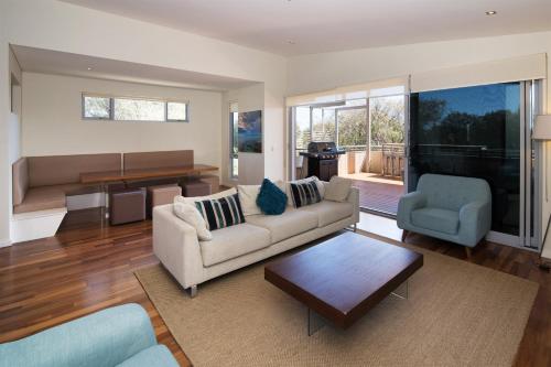 a living room with a couch and a table at Dunsborough Seascape in Quindalup