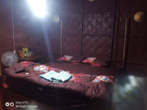 a room with a bed with two towels on it at ເຂົ້າໜຽວຟາມສະເຕ-Kao Niaw Farmstay in Luang Prabang