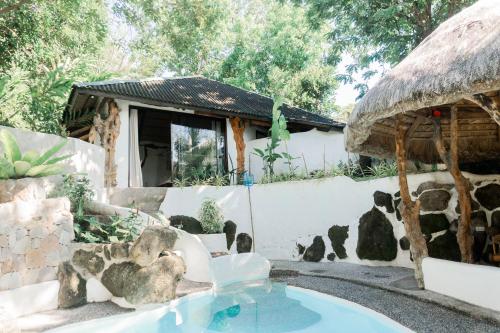 a pool in front of a house with a fountain at Balihao Resort in Mambajao