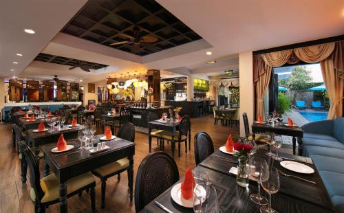 a restaurant with tables and chairs and a bar at Hoi An Golden Holiday Hotel & Spa in Hoi An