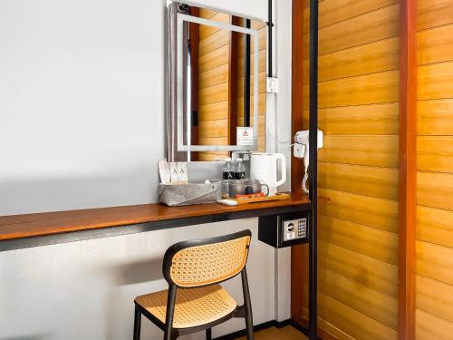a chair sitting at a counter with a mirror at A Coral Reefs Resort Langkawi by Manhattan Group in Pulau Chupak