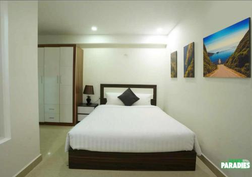 a bedroom with a white bed in a room at An Nam Paradise Dalat in Da Lat