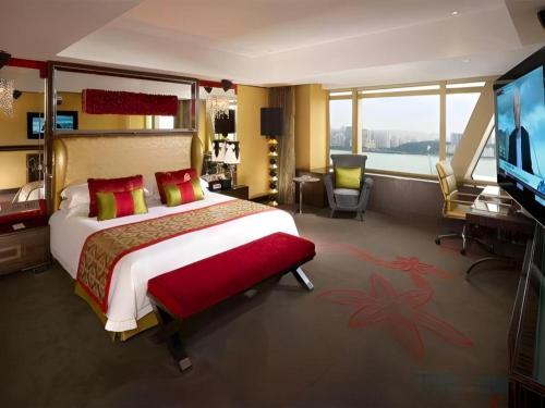 a hotel room with a large bed and a flat screen tv at Grand Lisboa Macau in Macau