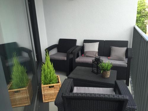 a balcony with two chairs and a table and plants at Horyzont Luksusowe apartamenty nad morzem z parkingiem Międzyzdroje in Międzyzdroje