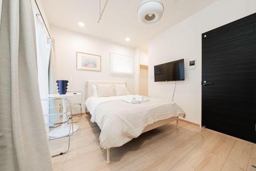 a bedroom with a bed and a television in it at shinjuku house in Tokyo