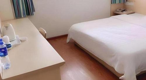 a hotel room with a white bed and two tables at 7 Days Inn Chengdu North Railway Metro Station in Chengdu