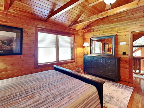 a bedroom with a bed and a dresser and a mirror at Crows Point Lakehouse in Swanton