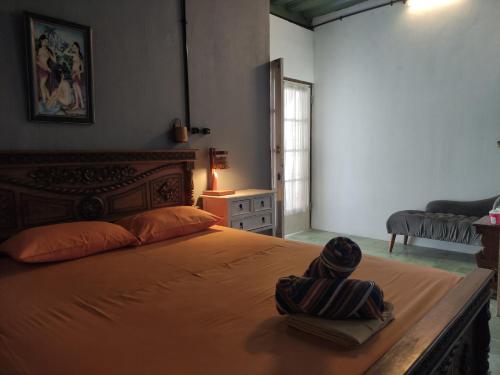 a bedroom with a large bed with a wooden headboard at Arjuna Garden Homestay in Yogyakarta