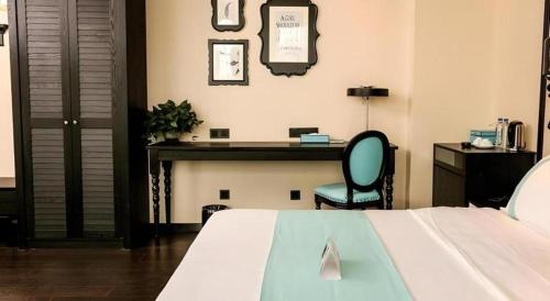a bedroom with a desk and a bed and a chair at Xana Hotelle·Ji'nan Hi-tech Zone Century Avenue Tangye in Jinan