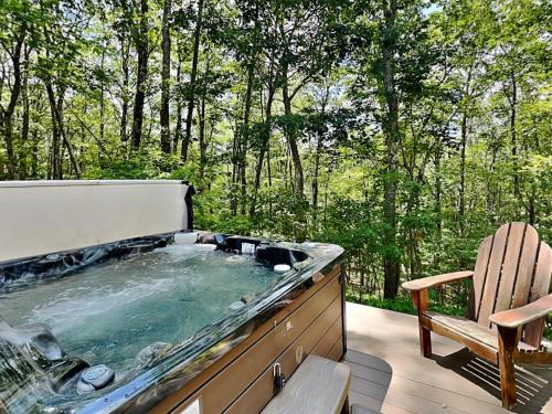 a hot tub on a deck with a chair at Logged Out in Oakland