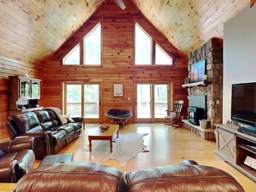 a living room with leather furniture in a log cabin at Logged Out in Oakland