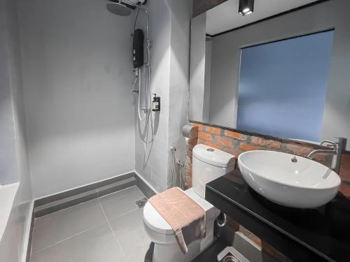 a bathroom with a white toilet and a sink at A Coral Reefs Resort Langkawi by Manhattan Group in Pulau Chupak