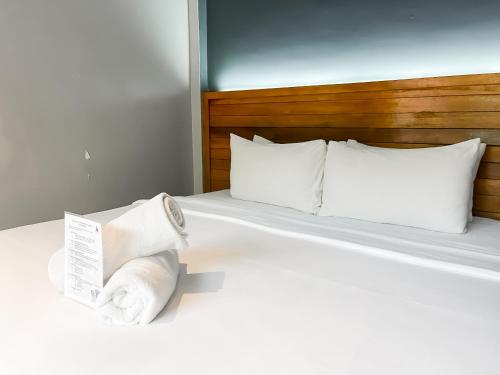 a bedroom with a bed with towels on it at A Coral Reefs Resort Langkawi by Manhattan Group in Pulau Chupak