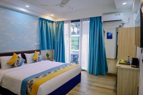 a bedroom with a large bed with blue curtains at h78 Iru in Hulhumale