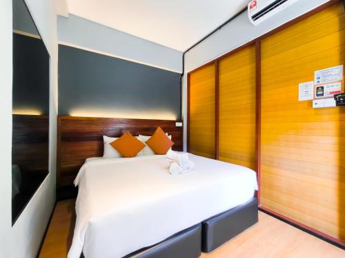 a bedroom with a white bed with orange pillows at A Coral Reefs Resort Langkawi by Manhattan Group in Pulau Chupak