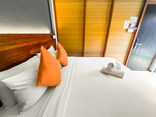 a bedroom with a bed with orange and white pillows at A Coral Reefs Resort Langkawi by Manhattan Group in Pulau Chupak
