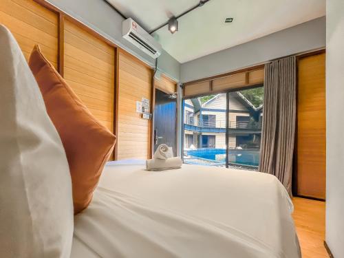 a bedroom with a white bed and a window at A Coral Reefs Resort Langkawi by Manhattan Group in Pulau Chupak