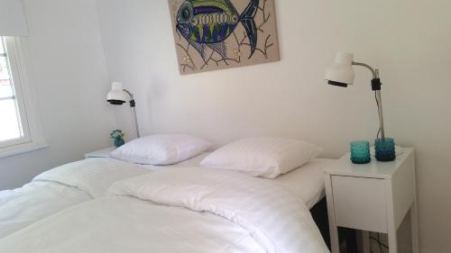 two white beds in a room with a lamp at Amazing Sea View Luleå in Luleå