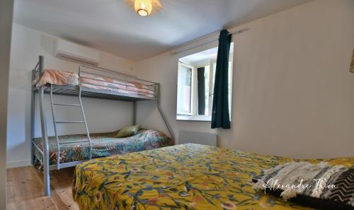 a bedroom with a bunk bed and a window at "La Tour", Logement cosy, au calme in Vertrieu
