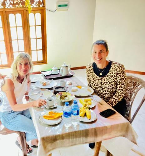 a man and woman sitting at a table with food at Udawalawa Eco Lodge in Udawalawe