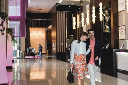 a man and a woman walking through a lobby at Riu Plaza New York Times Square in New York