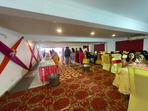 Un grupo de personas en una habitación con sillas amarillas. en Hotel Prem Ratna, en Dehradun