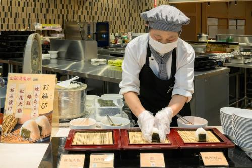 a chef preparing food in a restaurant kitchen at Senkeien Tsukioka Hotel in Kaminoyama