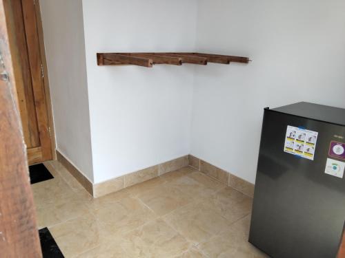 a black refrigerator in a room with a tile floor at Spear Villa in Bumbang