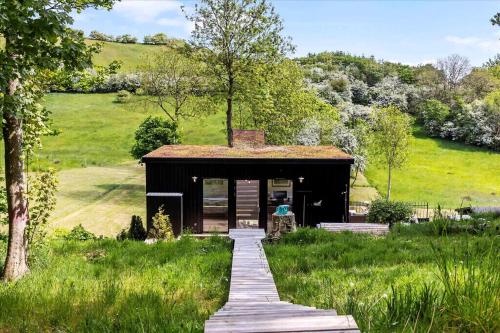 a small house in a field with a wooden walkway at Beautiful House In Fantastic Surroundings in Nykøbing Mors