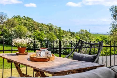 a wooden table with flowers on top of a fence at Beautiful House In Fantastic Surroundings in Nykøbing Mors