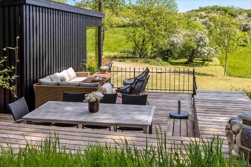 a wooden deck with a couch and a table at Beautiful House In Fantastic Surroundings in Nykøbing Mors