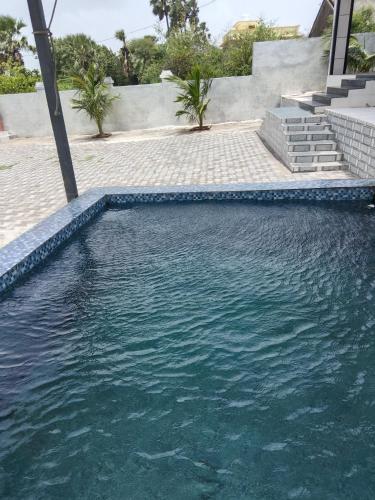 una piscina con agua azul clara en una casa en Ocean View Villa, en Boisar