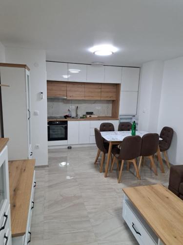 a kitchen with a table and chairs in a room at TARA apartman in Pojate