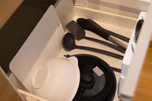 a white toilet in a box with utensils at Tomattoco KASUMI in Yamagata