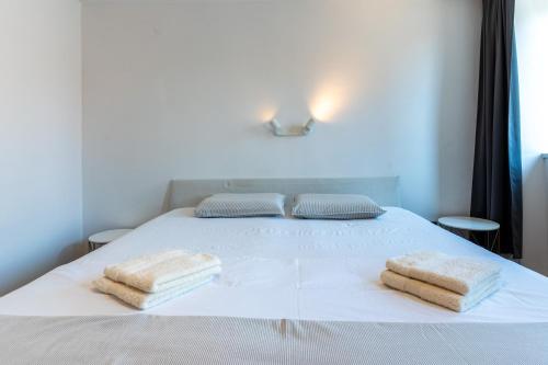 a white bed with two towels on top of it at Giannina in Cres