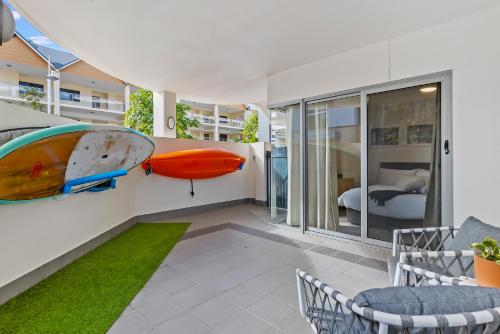 a living room with a surfboard on the wall at Dolphin Harbour Haven-family Friendly-canal Front in Mandurah