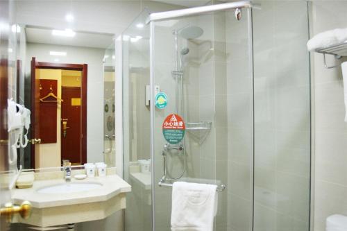 a bathroom with a glass shower and a sink at GreenTree Inn JiangSu SuZhou International Film City South JinShan Road Express Hotel in Suzhou