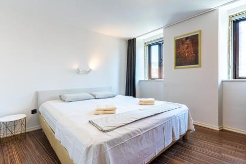 a white bedroom with a bed with towels on it at Giannina in Cres