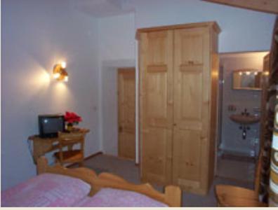 a bedroom with a bed and a cabinet and a sink at Hotel Cristallina in Sils Maria