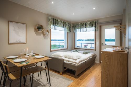a bedroom with a bed and a table and a dining room at Arctic Snow Lake Mini Lodge in Rovaniemi