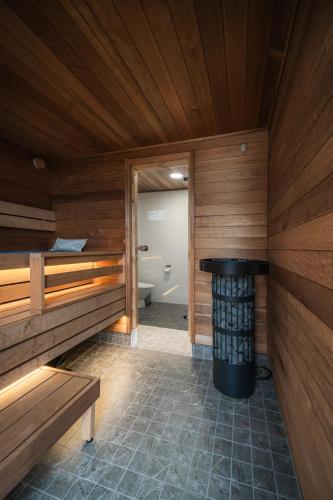 a sauna with a tub and a toilet in a room at Arctic Snow Lake Mini Lodge in Rovaniemi