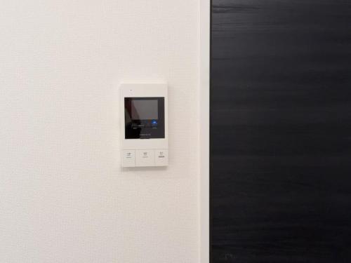 a white switch on a wall next to a blackboard at shinjuku house in Tokyo