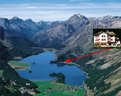 a house on top of a mountain with a lake at Hotel Cristallina in Sils Maria