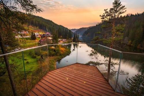 a view of a body of water with a wooden walkway at Lake House in Izvoru Mureşului