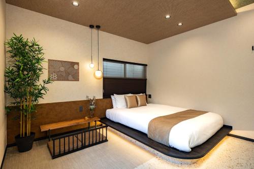 a bedroom with a bed and a potted plant at JAPAVISTA Hinata in Osaka